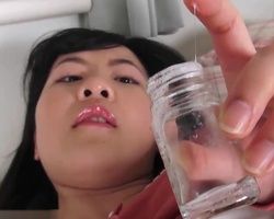 Japanese girl spreads her shaved wet pussy and scoops her juices into a vial